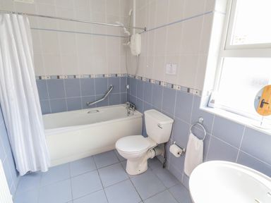 A bathroom with a bathtub shower toilet sink and window at Tieve Baun in Ballintrillick near Kinlough County Sligo