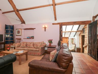 A living room with sofas coffee table and wooden beams at The Barn in Bicknoller