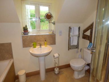 A bathroom with a pedestal sink toilet bathtub and shower at The Old Mill in Dolau near Llandrindod Wells
