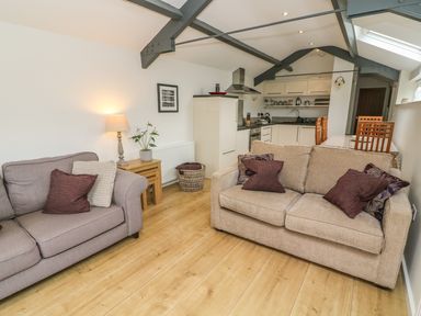 A living room with two sofas next to a kitchen and dining area at The Potting Shed in Burton-in-Kendal near Kirkby Lonsdale