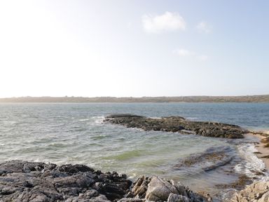 A rocky shoreline with water and distant land at Teach Teolai in Carraroe County Galway