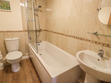 A bathroom with a bathtub shower toilet and sink at Hendoll Cottage 2 Fairbourne near Dolgellau