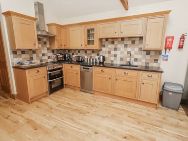 A kitchen with cabinets and appliances at Grey Croft in Embleton