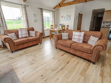 A living room with two sofas and a dining table at Grey Croft Embleton