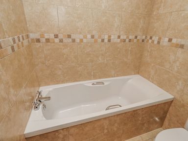 A bathtub with a tap in a bathroom at Grey Croft in Embleton
