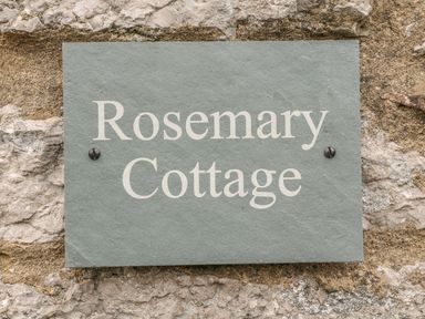 A sign reading Rosemary Cottage mounted on a stone wall at Rosemary Cottage in Clawthorpe near Burton-in-Kendal