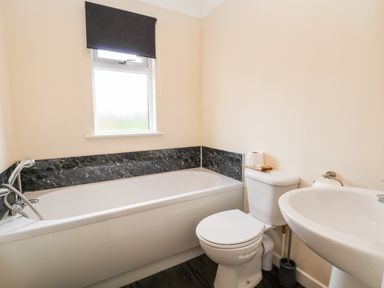 A bathroom with a bathtub a toilet and a sink at Callow Lodge 5 in Beaconsfield Holiday Park