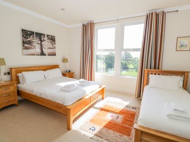 A bedroom with a double bed and a single bed with towels on them at Eden Lodge in Bardsea