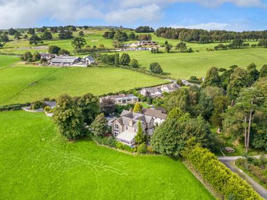 A countryside landscape with houses trees fields and hills at Eden Lodge in Bardsea