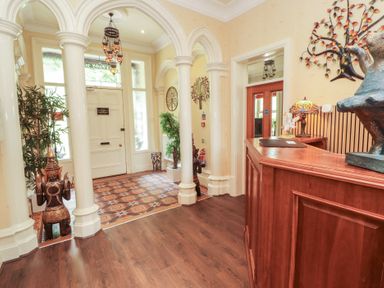 A hallway with a reception desk and decorative elements at Eden Lodge in Bardsea