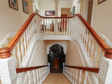 A staircase and railings in a hallway at Eden Lodge in Bardsea