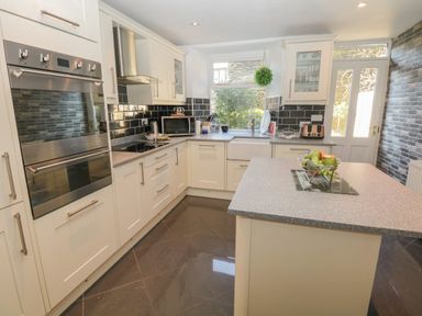 A kitchen with white cabinets a gray countertop a kitchen island and appliances at 48 Oak Street in Windermere