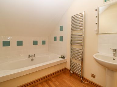 A bathroom with a bathtub sink and a heated towel rail at Meader Barn in Peter Tavy near Tavistock