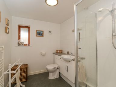 A bathroom with a toilet sink shower and small window at Roan Cottage in Royal Wootton Bassett