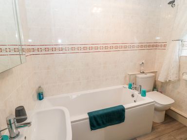 A bathroom with a bathtub sink and toilet at St Cuthberts Cottage in Beal near Holy Island