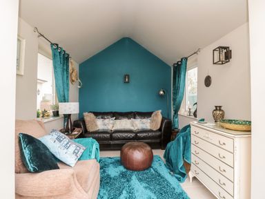 A living room with two sofas a blue rug and a white chest of drawers at St Cuthberts Cottage Beal near Holy Island