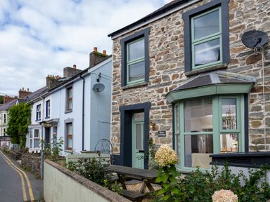 A street view showing stone and painted houses with windows and gardens at Rose Cottage in St Dogmaels near Cardigan