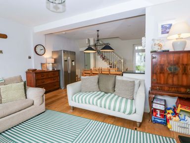 A living room with a sofa and dining area at Rose Cottage in St Dogmaels near Cardigan
