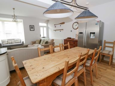 A kitchen with a dining table and refrigerator at Rose Cottage in St Dogmaels near Cardigan
