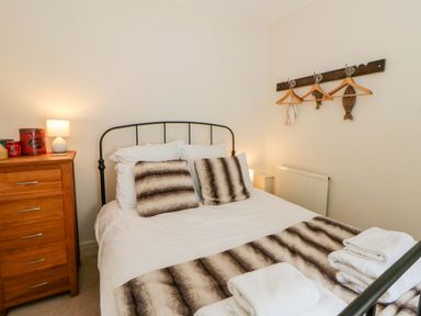 A bedroom with a bed and dresser at Rose Cottage St Dogmaels near Cardigan