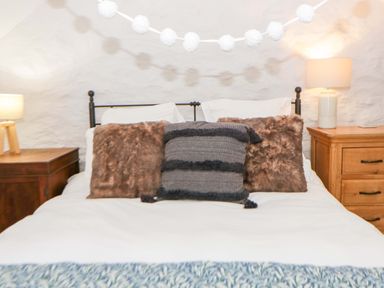 A bedroom with a bed and bedside tables at Rose Cottage in St Dogmaels near Cardigan