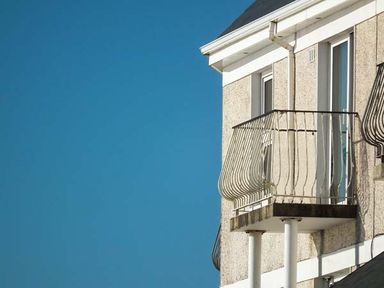 A section of a building with two small balconies and a clear blue sky at The Beach House Apartment in Buncrana County Donegal