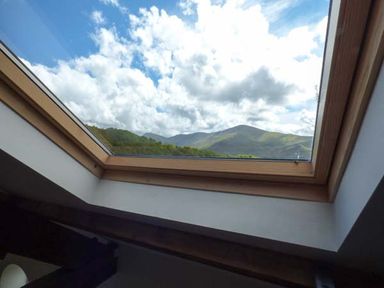 A skylight window showing clouds and hills beyond at Capel Dinorwig in Llanberis