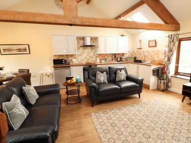 A living room with a kitchen area at Stable Cottage in Bolton Low Houses
