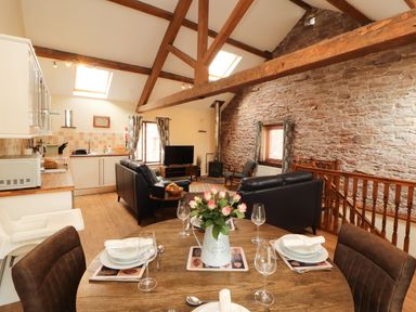 A living room with a kitchen area and dining space at Stable Cottage in Bolton Low Houses