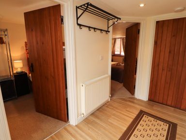 A hallway with doors and a coatrack at Stable Cottage in Bolton Low Houses
