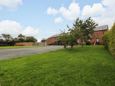 An outdoor area with a gravel driveway and building at Stable Cottage in Bolton Low Houses