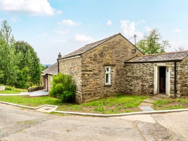 An outdoor area with a stone building and pathway at Dove Cottage at the Graythwaite Estate near Hawkshead