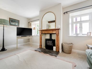 A living room with a television and fireplace at Dove Cottage at the Graythwaite Estate near Hawkshead