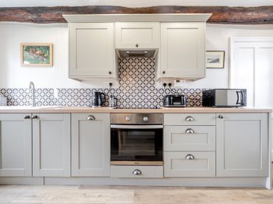 A kitchen with cabinets and appliances at Dove Cottage at the Graythwaite Estate near Hawkshead
