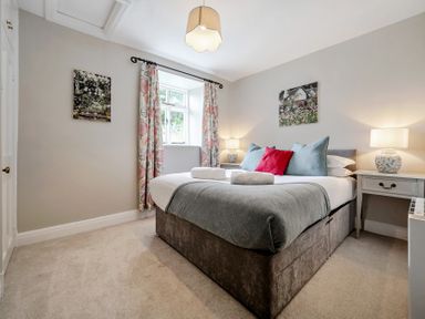 A bedroom with a bed and bedside lamps at Dove Cottage at the Graythwaite Estate near Hawkshead