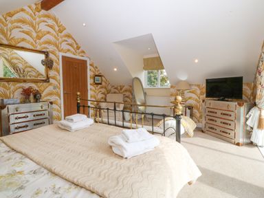 A bedroom with a metal bed frame and folded towels on the bed at Nant-yr-Rhedyn in Red Wharf Bay
