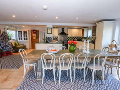 A kitchen with a dining table and chairs at Nant-yr-Rhedyn in Red Wharf Bay