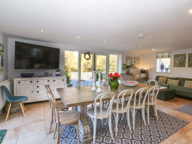 A dining room with a table and chairs at Nant-yr-Rhedyn in Red Wharf Bay