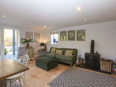 A living room with a sofa and coffee table at Nant-yr-Rhedyn in Red Wharf Bay