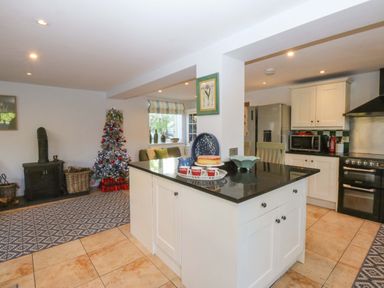 A kitchen with a stove and refrigerator at Nant-yr-Rhedyn in Red Wharf Bay