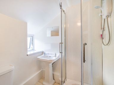 A bathroom with a pedestal sink a shower cabin and a small window at No 7 Spark Bridge near Ulverston