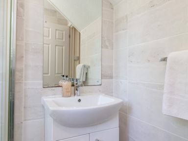 A bathroom sink with soap dispensers and a mirror above at Moorside in Horrabridge near Tavistock