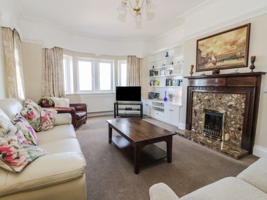 A living room with sofas a wooden coffee table and a fireplace at Seascape in Bridlington