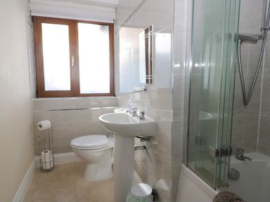A bathroom with a toilet sink and bathtub shower at Seascape in Bridlington