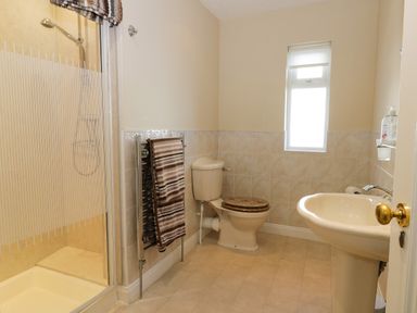 A bathroom with a shower cubicle towel radiator toilet and sink at Seascape in Bridlington