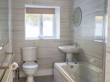 A bathroom with a toilet sink bathtub and window at The Nook in Bowness-On-Windermere