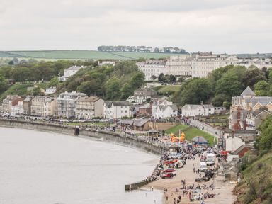 A coastal town with buildings along the shoreline and people on the beach at Sunny Bay in The Bay near Filey