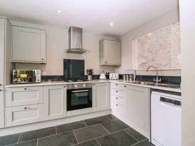 A kitchen with cabinets, stove, and sink at The Lodge, Lower Trefedw Pandy near Abergavenny