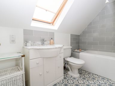 A bathroom with a sink cabinet toilet and bathtub under a skylight at Hurst Green in Ewyas Harold near Hereford