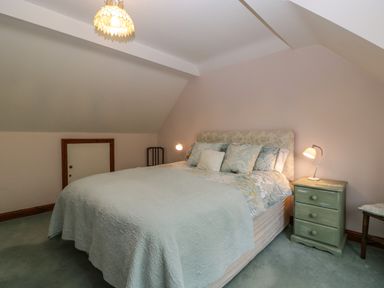 A bedroom with a double bed bedside table lamp and small door at Hurst Green in Ewyas Harold near Hereford